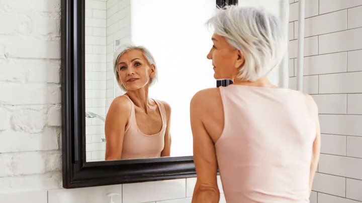 Woman looking at her milia in the mirror