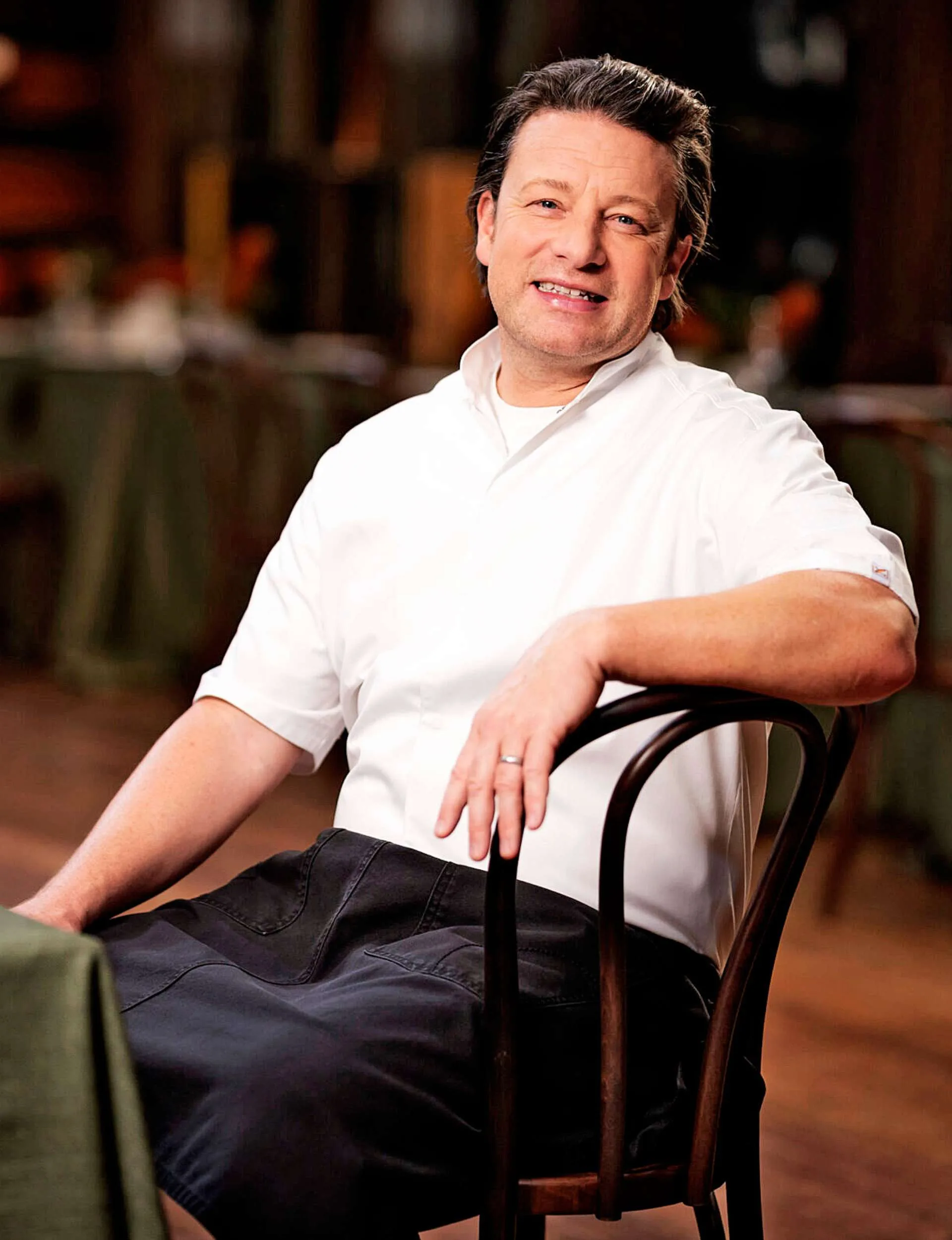 Jamie Oliver sitting at a table