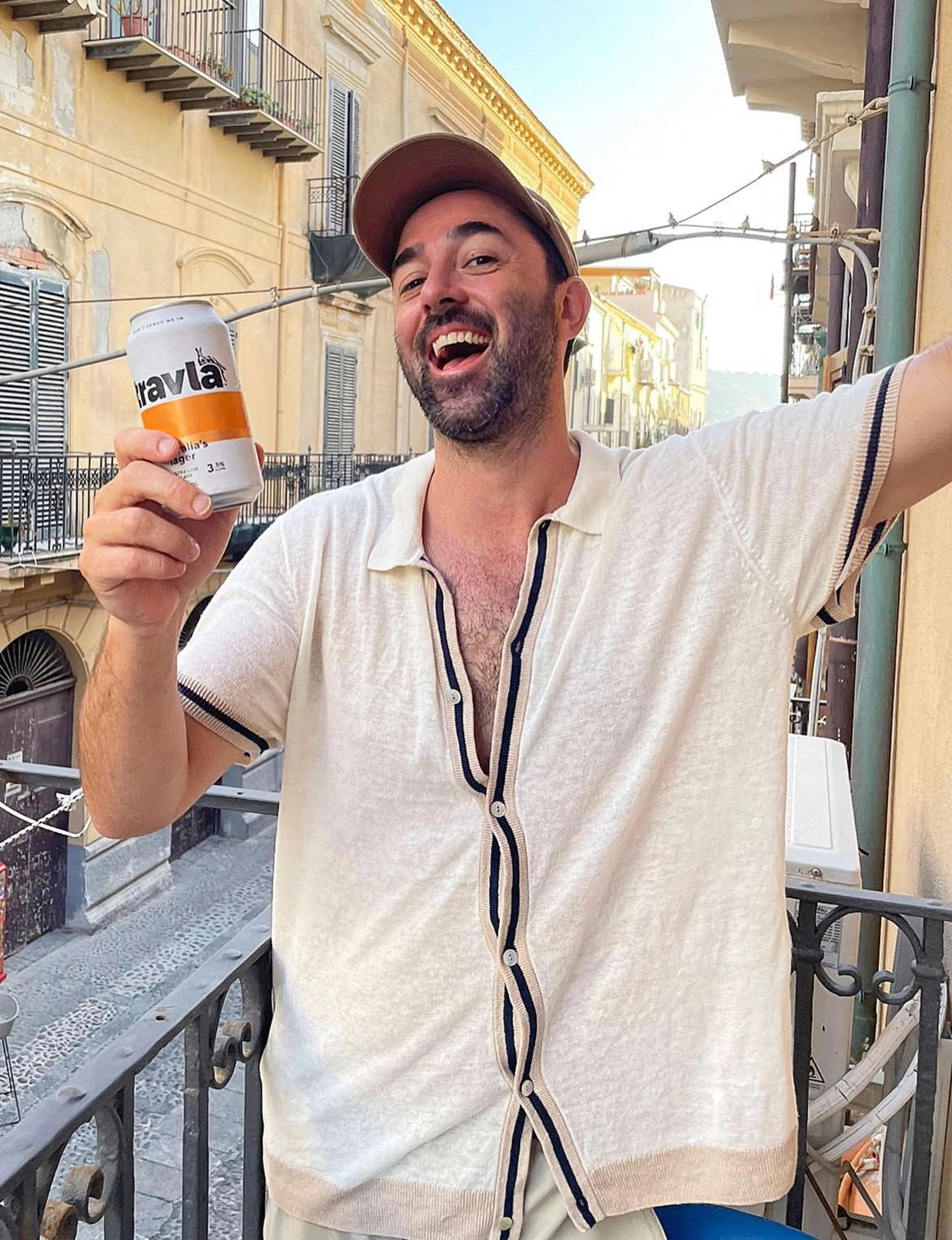 MasterChef judge Andy Allen holding up a beer can on a balcony
