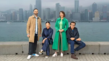 The 2024 MasterChef judges sitting and standing on a concrete pillar in front of a city skyline