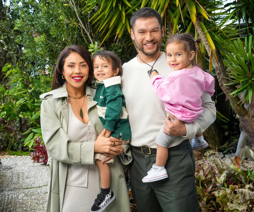 The proud parents holding their two kids ion a bushy footpath