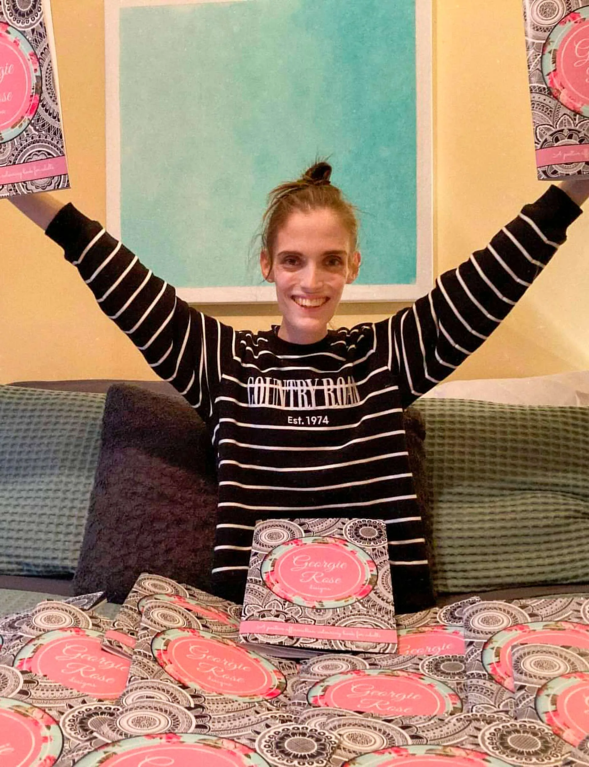Georgia holding up her printed and published colouring book
