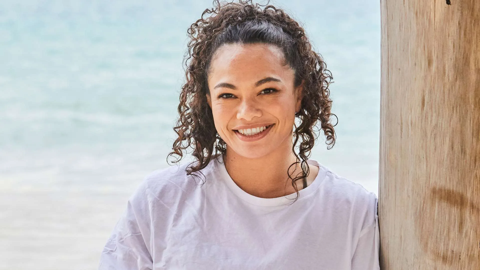 Tayla ford leaning against a wooden pole