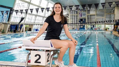 Erika Fairweather sitting beside an Olympic swimming pool