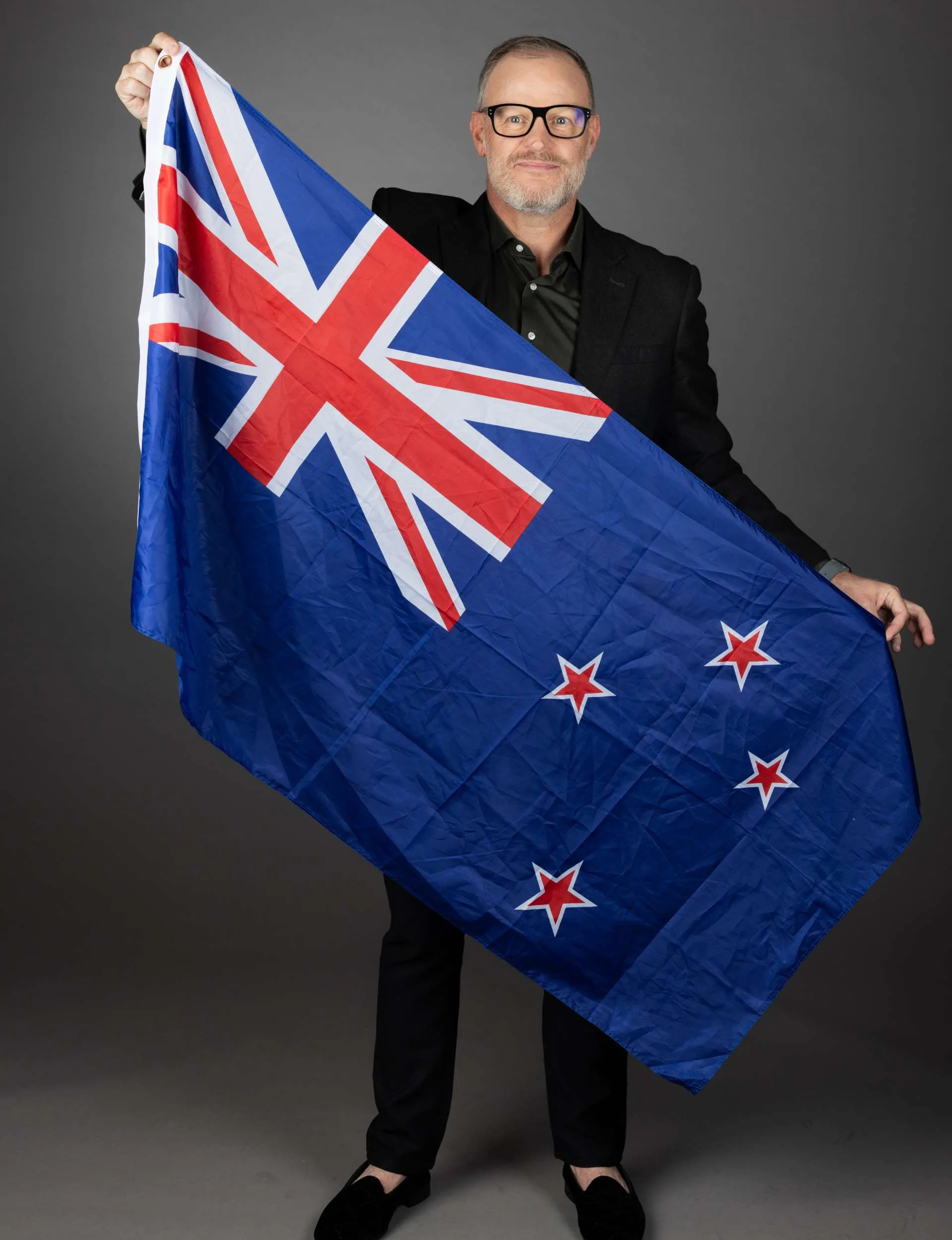 Andrew Mulligan waving a New Zealand flag