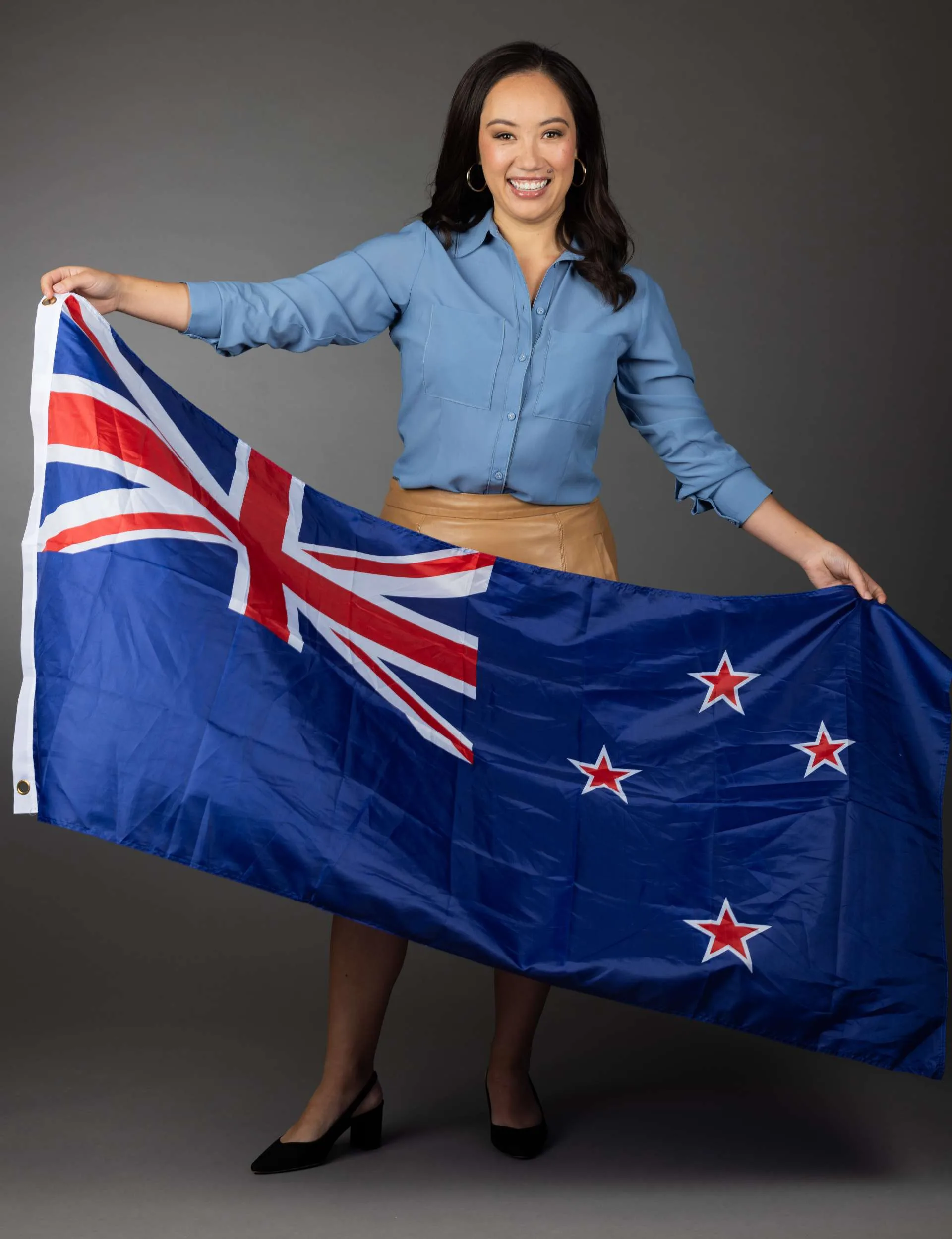 Sky Sport presenter Kimberlee Downs waving a NZ flag before the Olympics