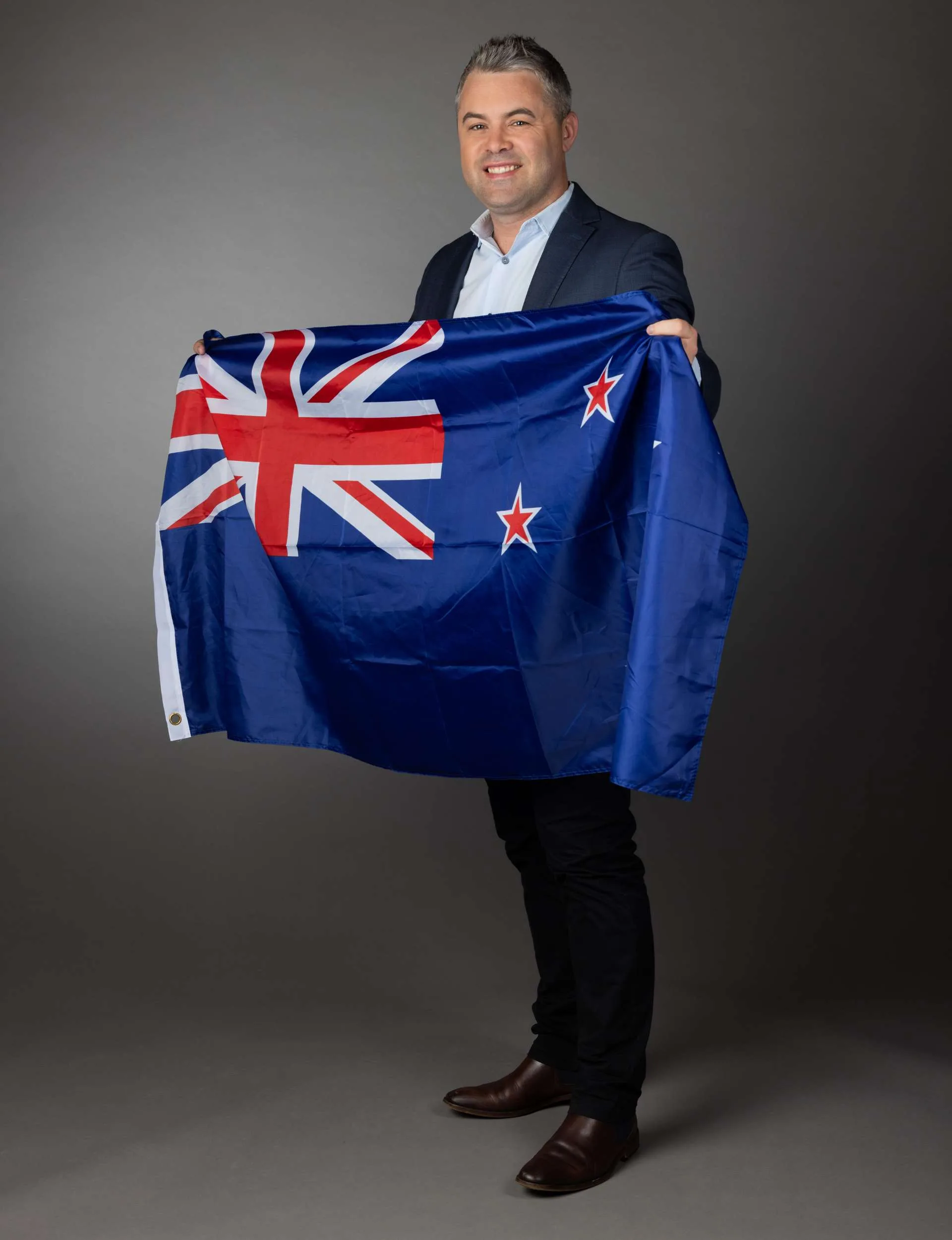 Sky Sport presenter Jeff McTainsh holding a New Zealand flag before the Olympics