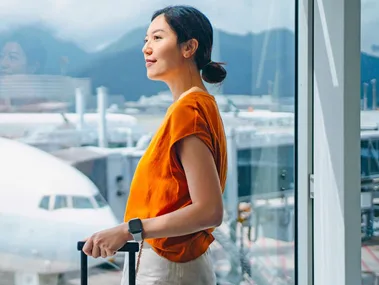 Woman looking out of a window at the planes at an airport