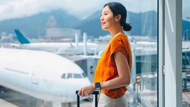 Woman looking out of a window at the planes at an airport