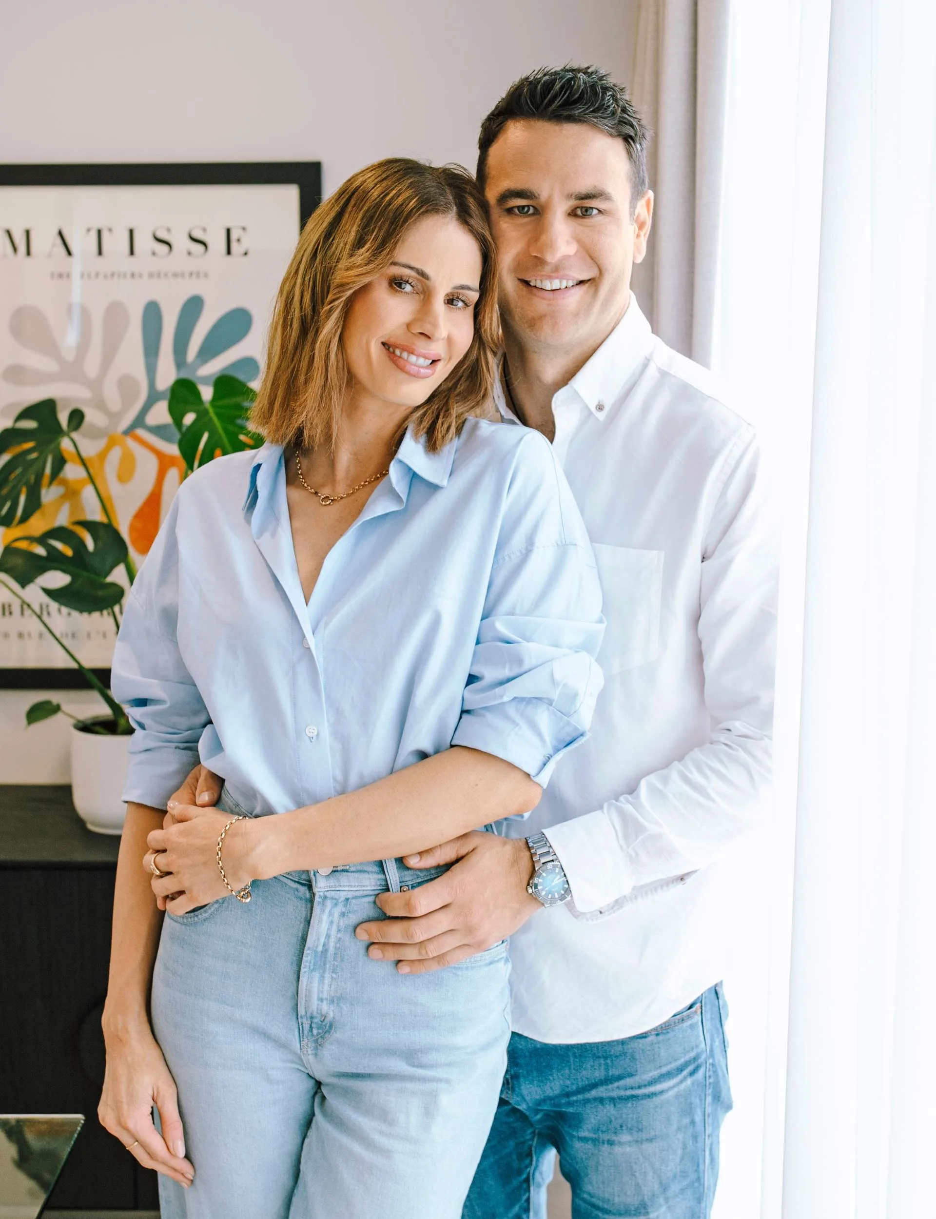 Wilhelmina and Ben standing together beside white airy curtains