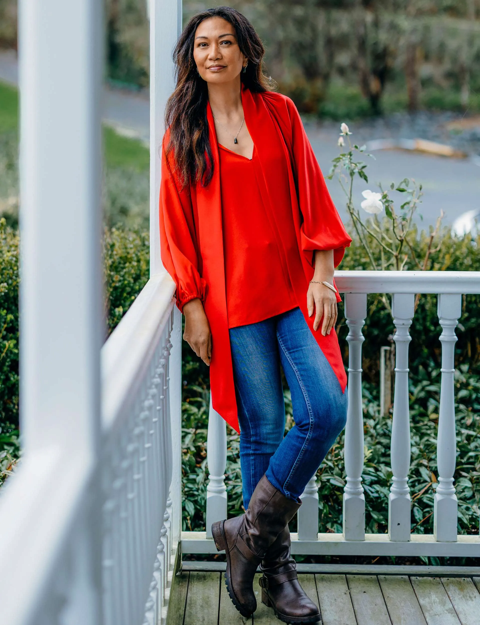Boh on a porch in front of white railing