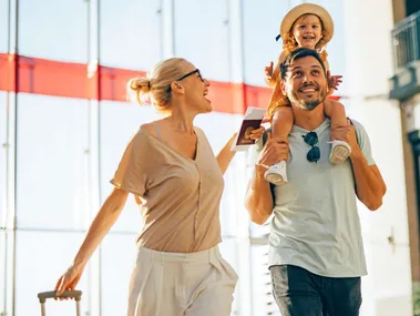 A young family walking through the airport before flying economy