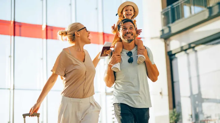 A young family walking through the airport before flying economy