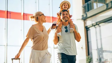 A young family walking through the airport before flying economy