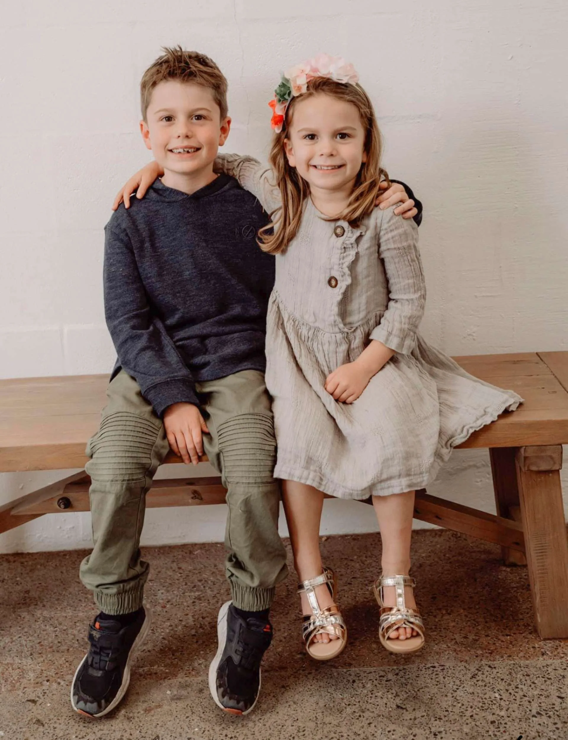 Nick and Sophie's kids sitting on a wooden bench together
