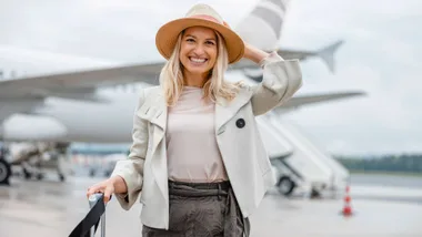 A woman smiling after her flight from using her in-flight beauty essentials