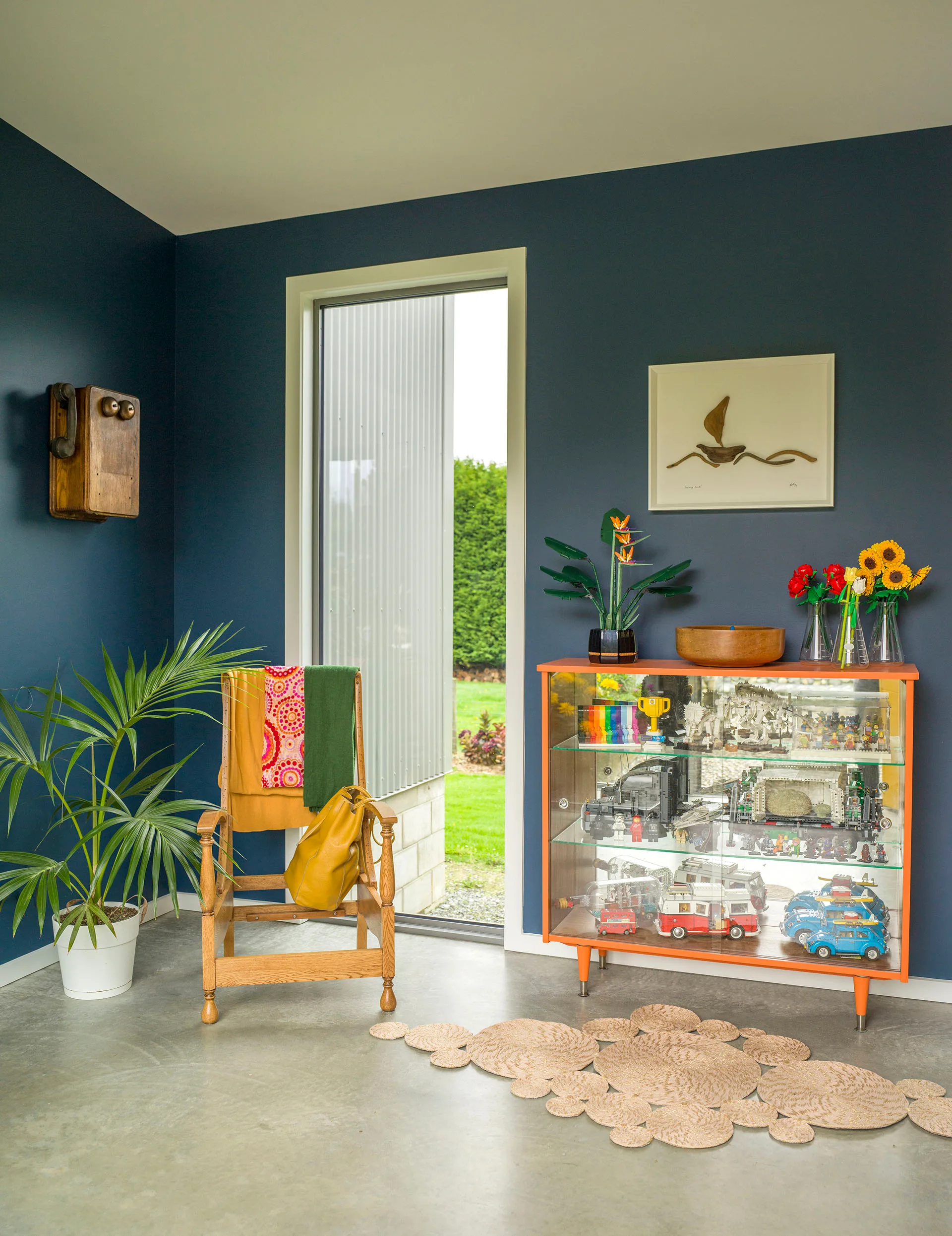 Invercargill home hallway painted in Resene Shadowy Blue, which is offset by Bronwen&rsquo;s Journey South driftwood art, an old telephone box (used to store keys) and a chair frame 