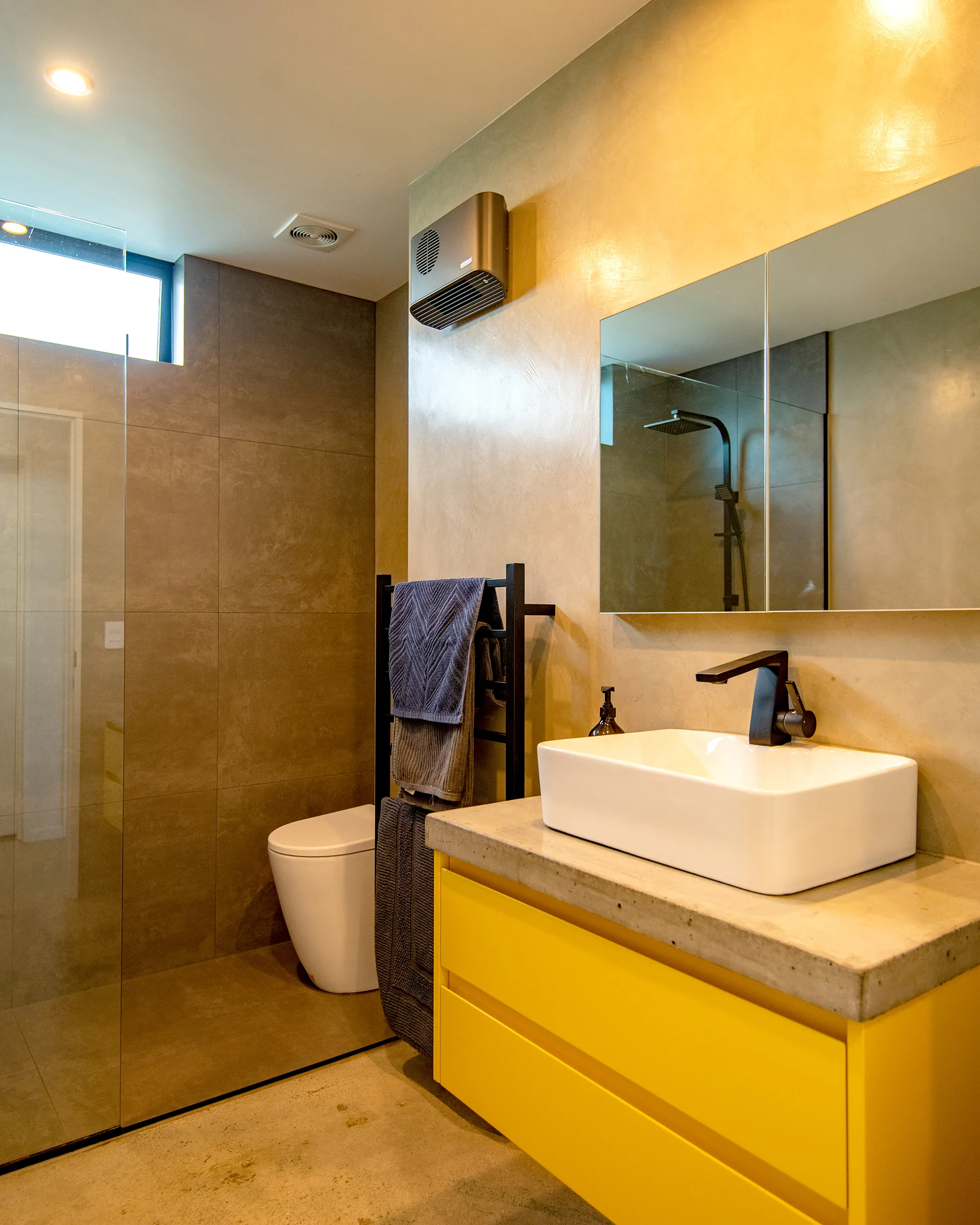 In the bathroom of the 2024 Resene Colour Home Award winning home, a custom vanity in Resene Hive acts as a playful burst of yellow