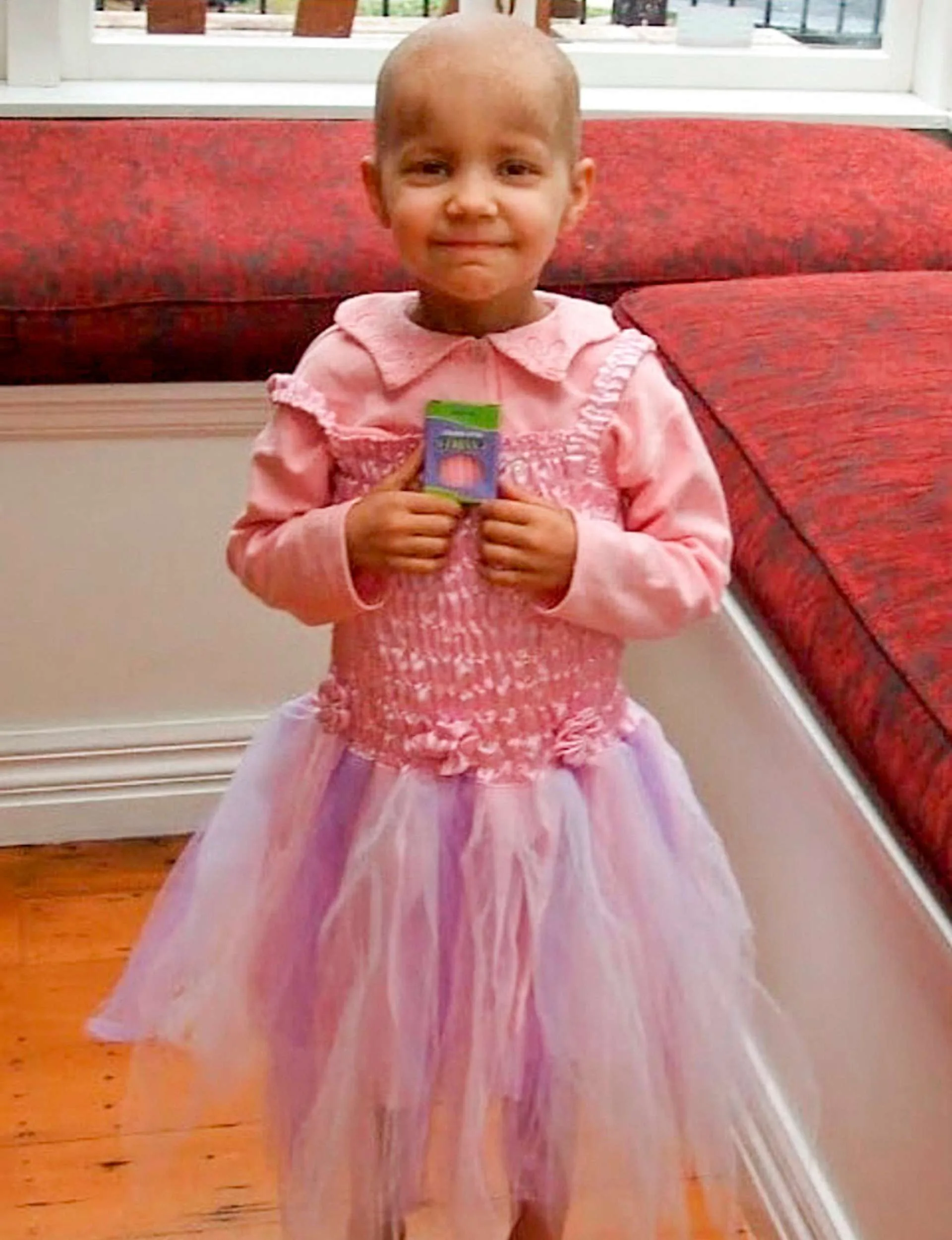 Smiling with a birthday present at age four