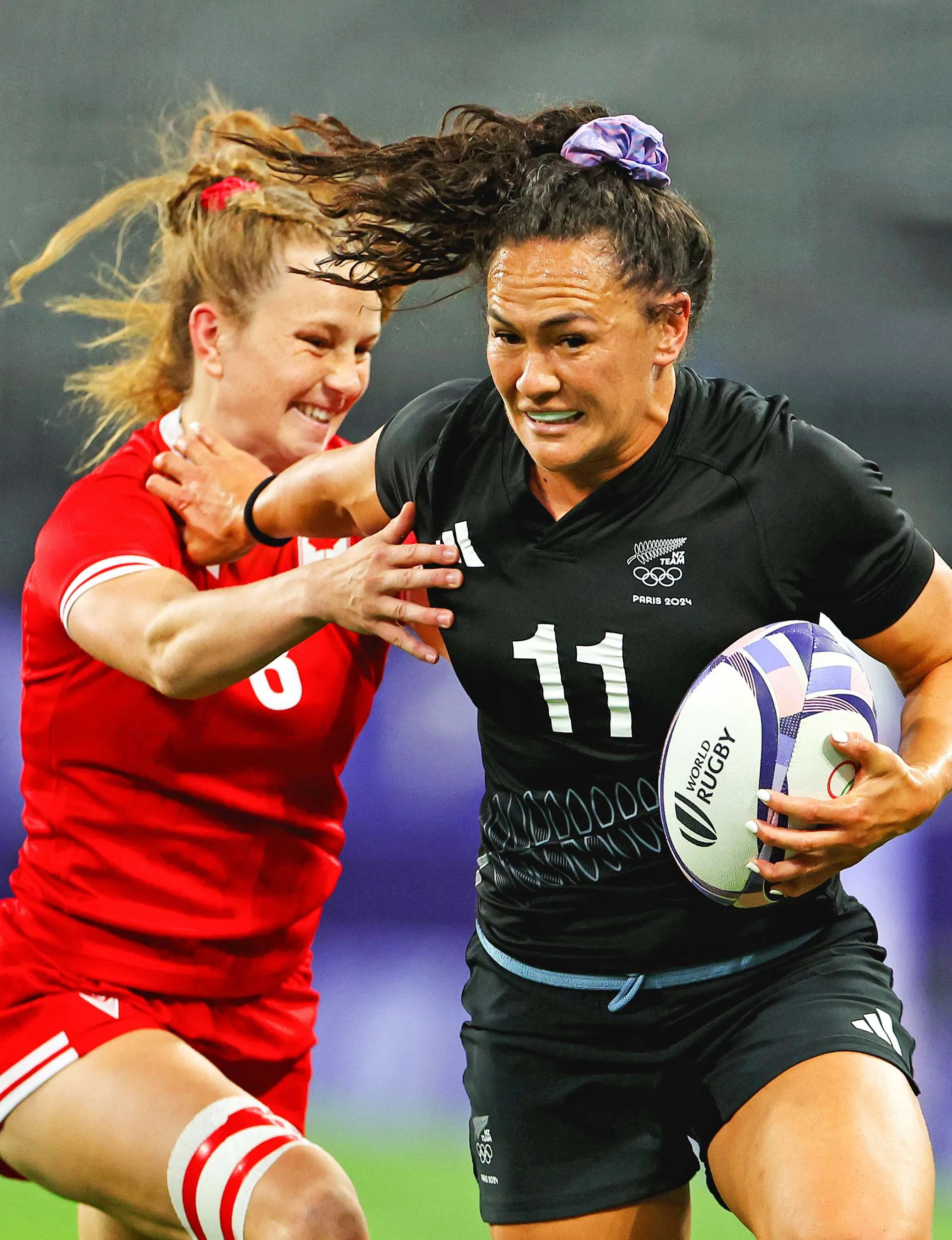 Portia Woodman-Wickliffe fending off a Canadian player