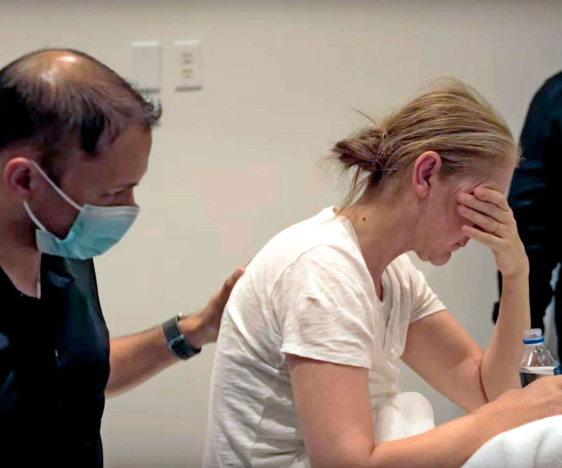 Cèline Dion being paten on the back by a doctor
