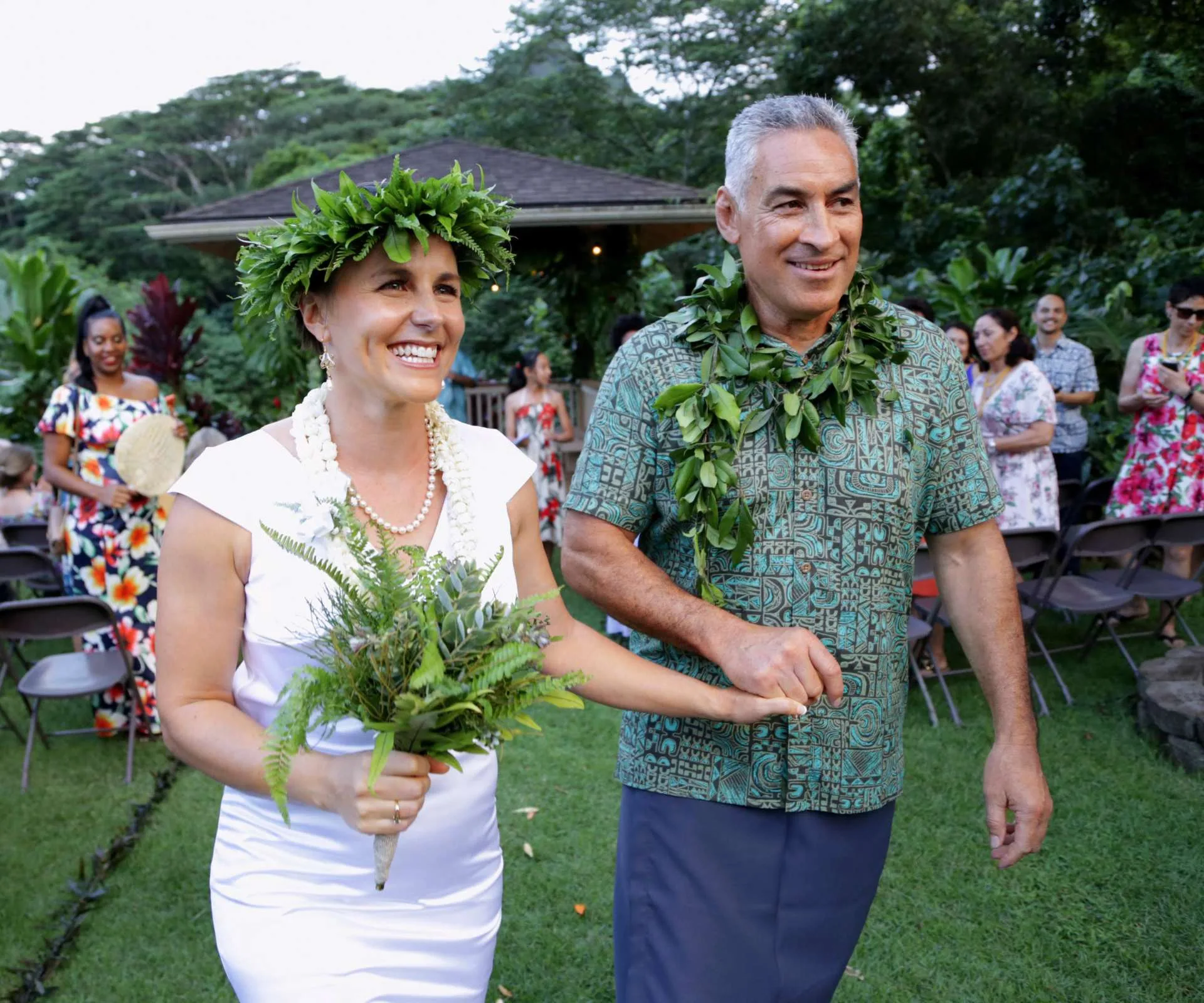 Frank Bunce at his wedding to Jess in Hawai'i with leafy leis around their heads and necks