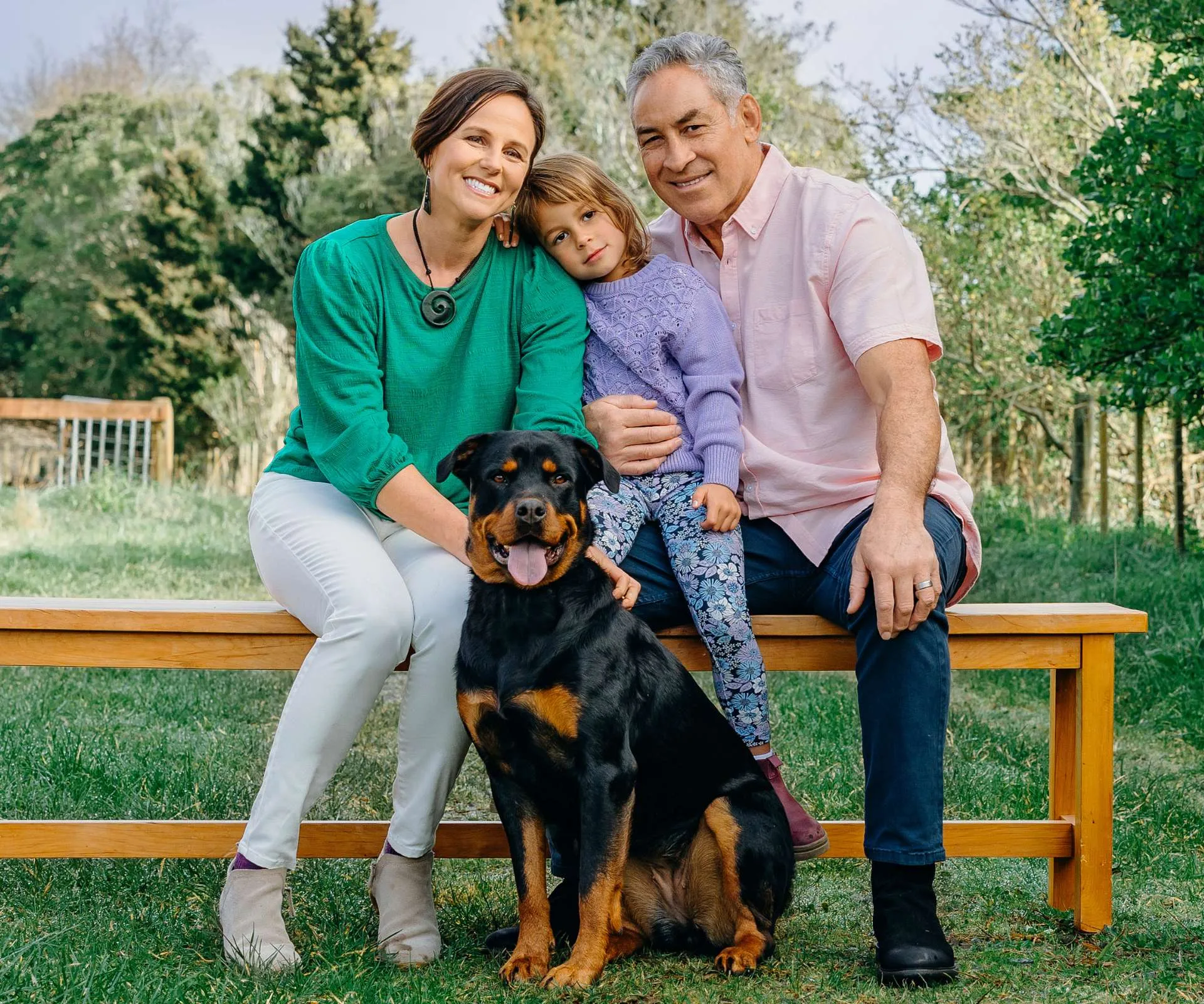 Frank with wife Jess and daughter Tillie sitting on a bench behind their dog