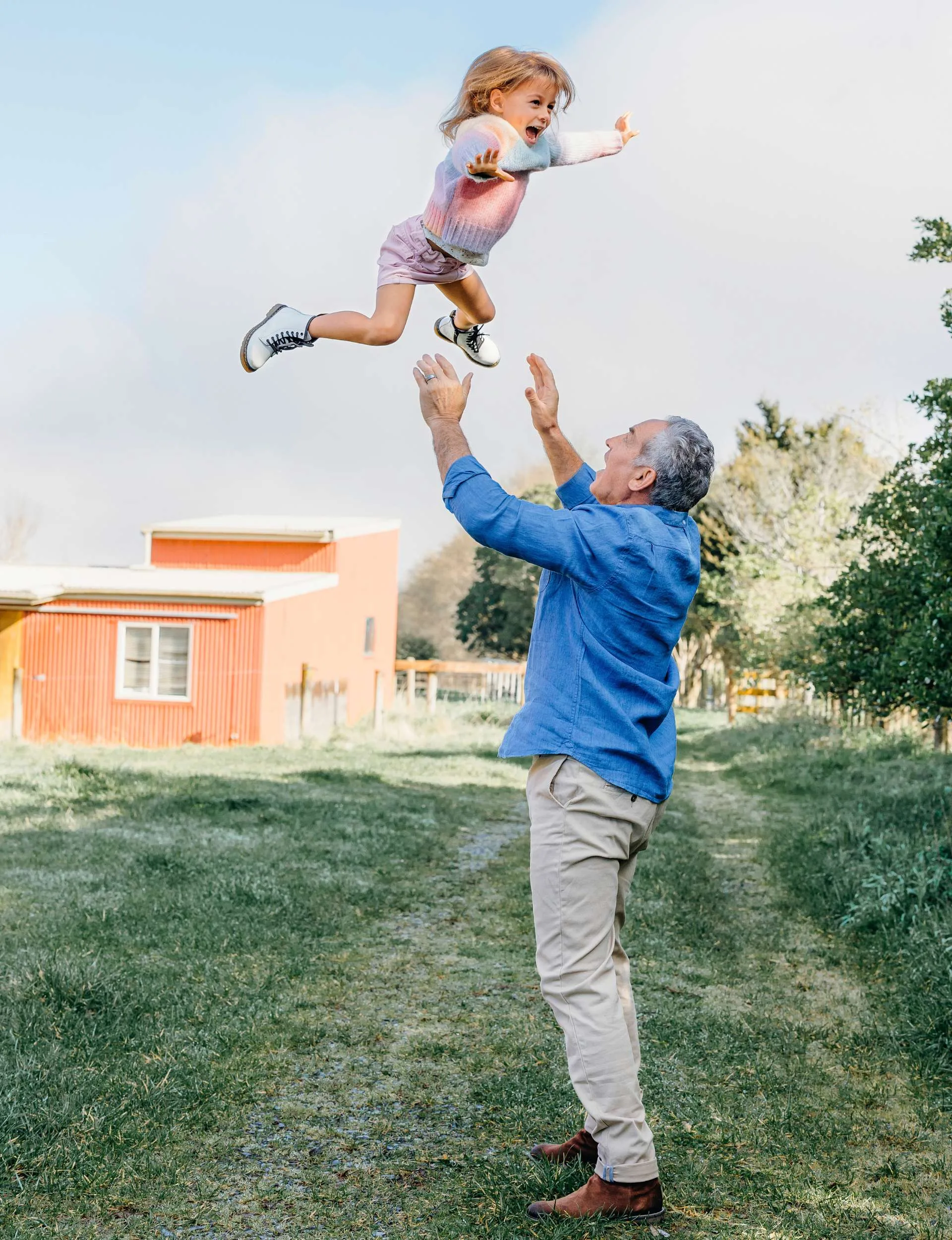 Frank Bunce throwing daughter Tillie up in the air above him