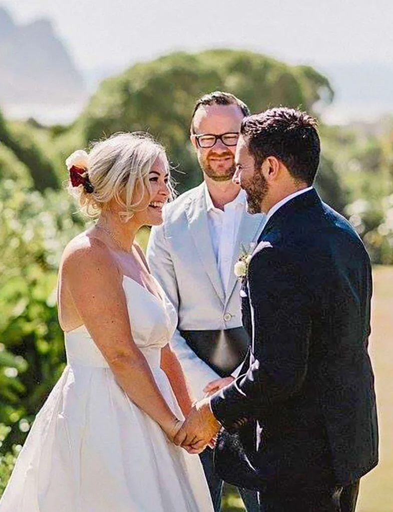 Flynny standing behind Sarah as she marries husband Luke