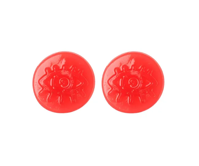 Two round red candies with an eye symbol embossed on them against a white background.