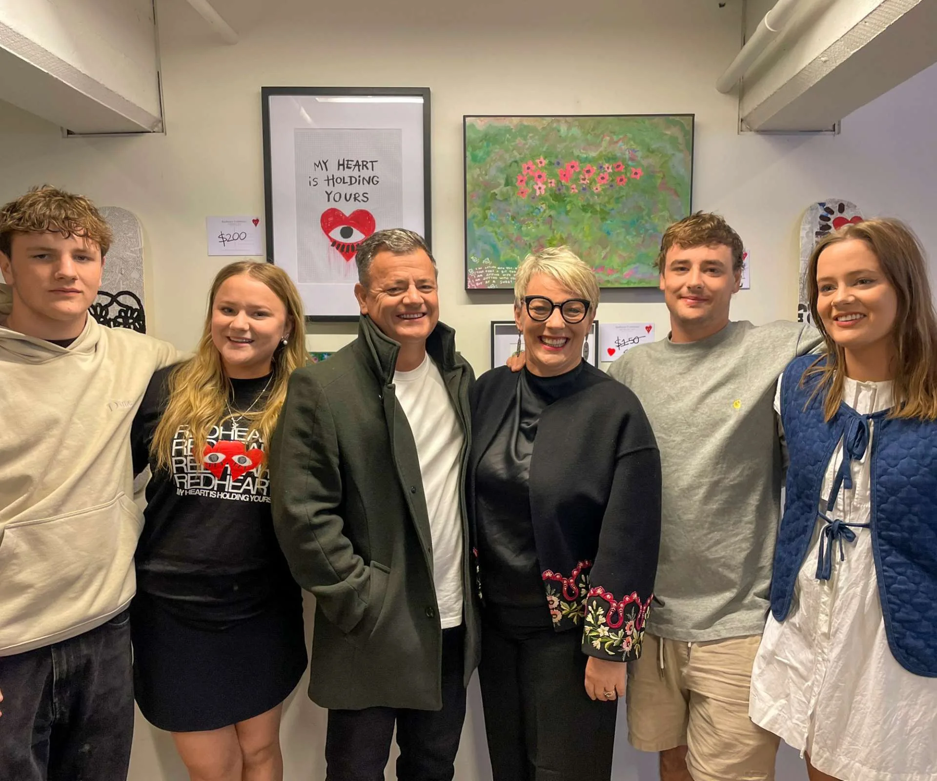 Lisa with her family in front of a wall of framed art prints