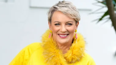 Lisa O'Neill smiling in a yellow furry collared shirt