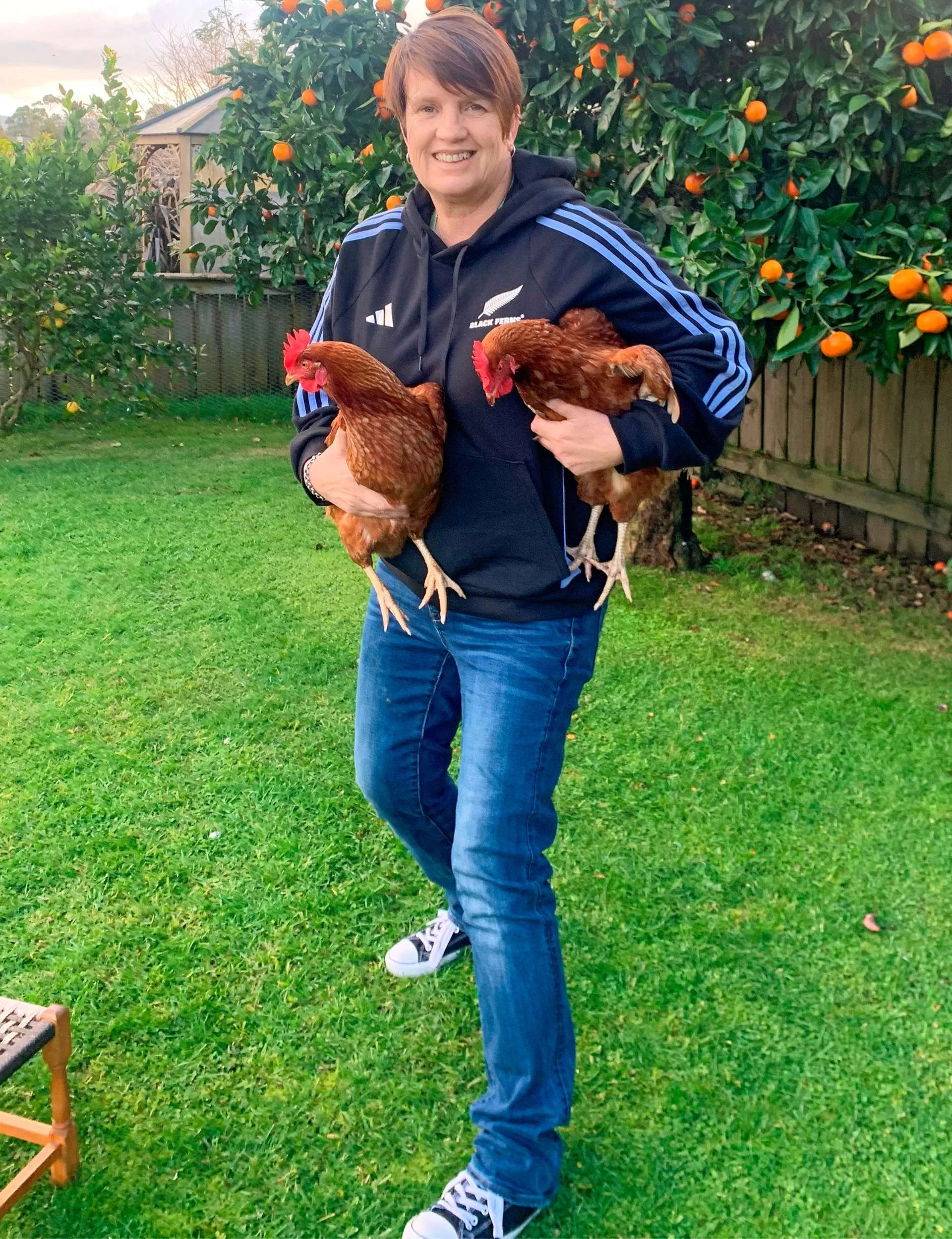 Jane holding her chickens under each arm