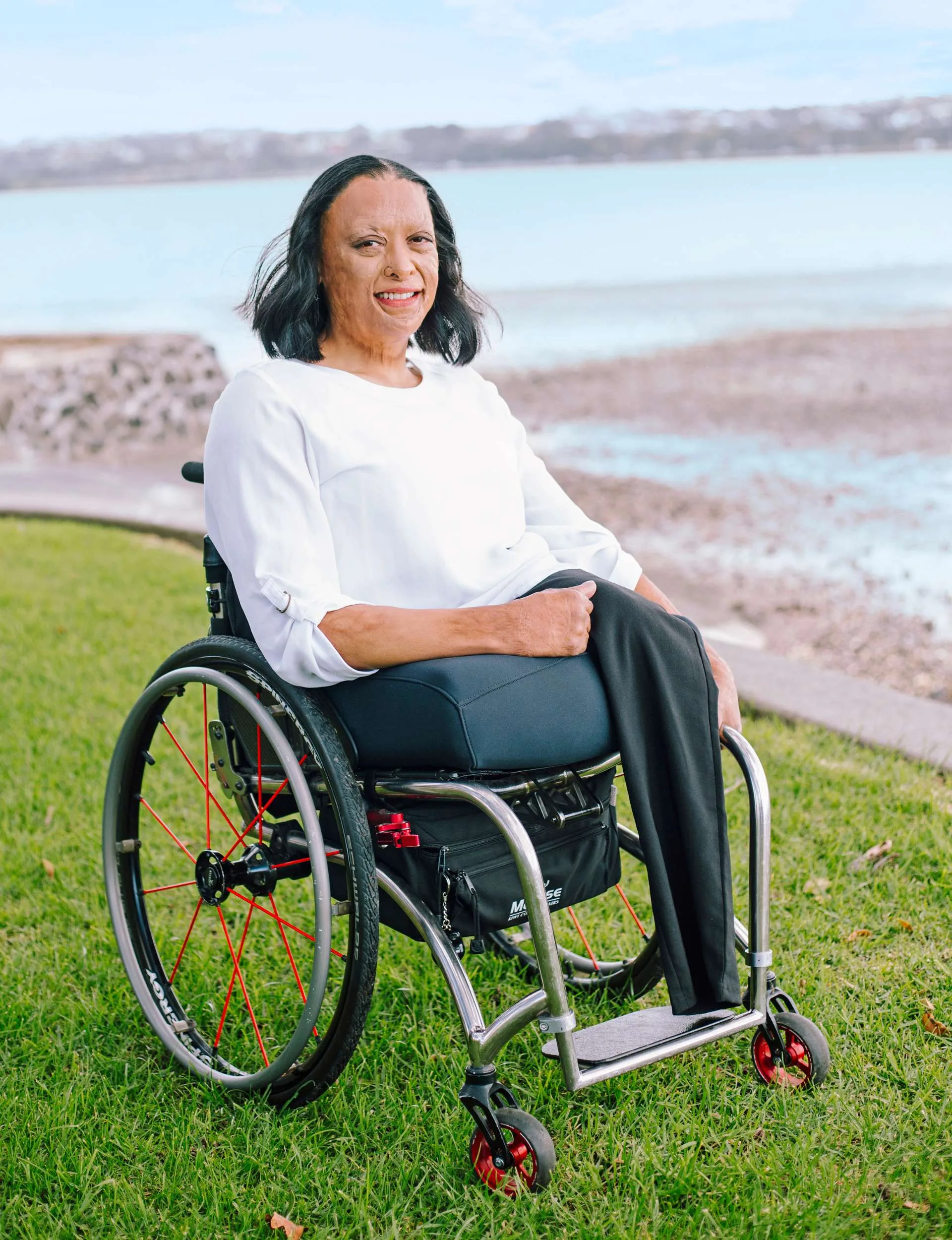 Maia Marshall-Amai in her wheelchair by a beach