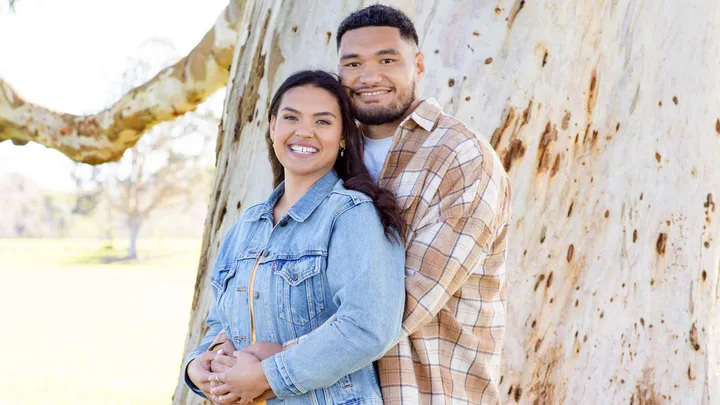 Cameron Suafoa and partner Britt in front of a tree trunk