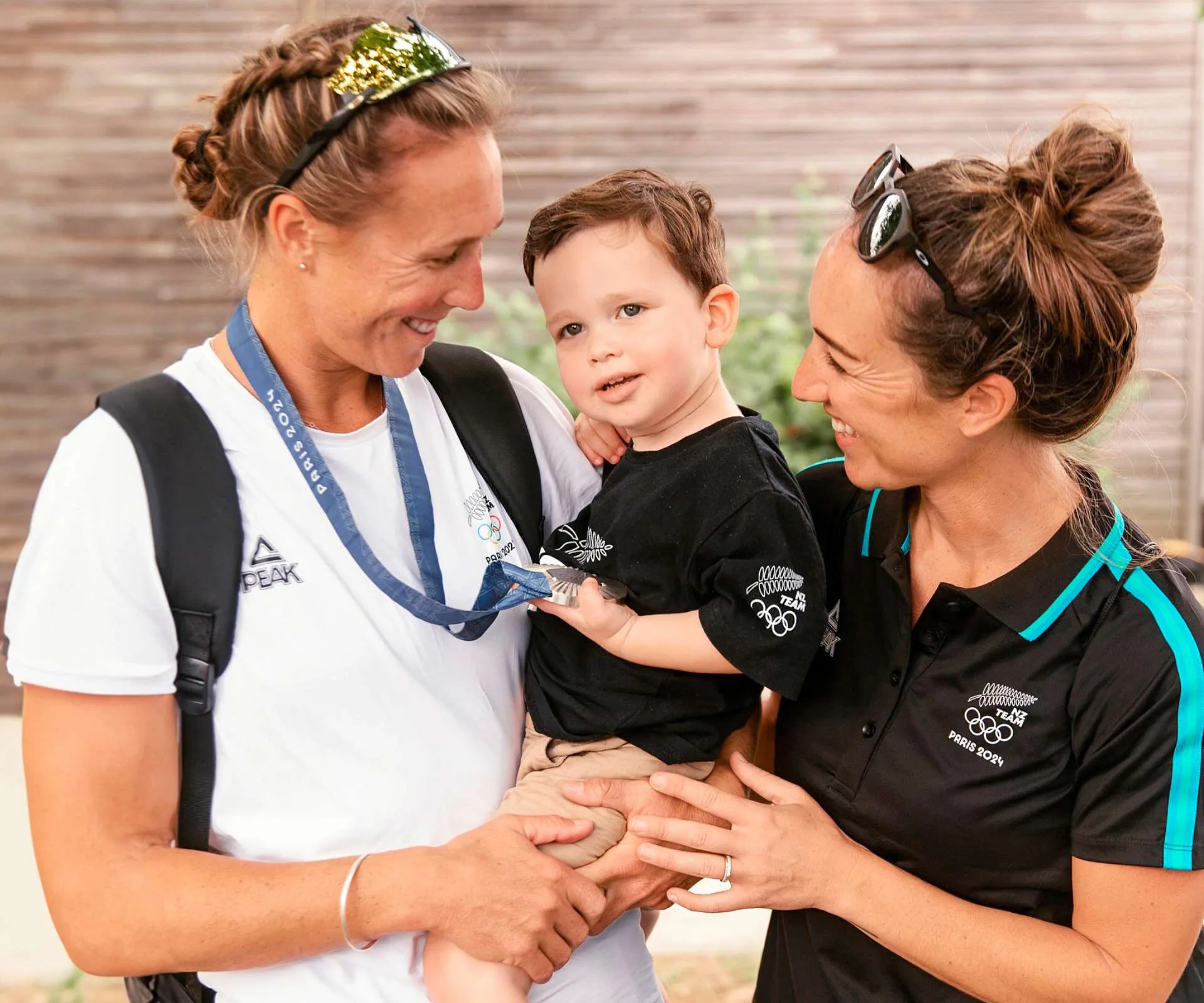 Emma Twigg and her wife holding their son after her second placing