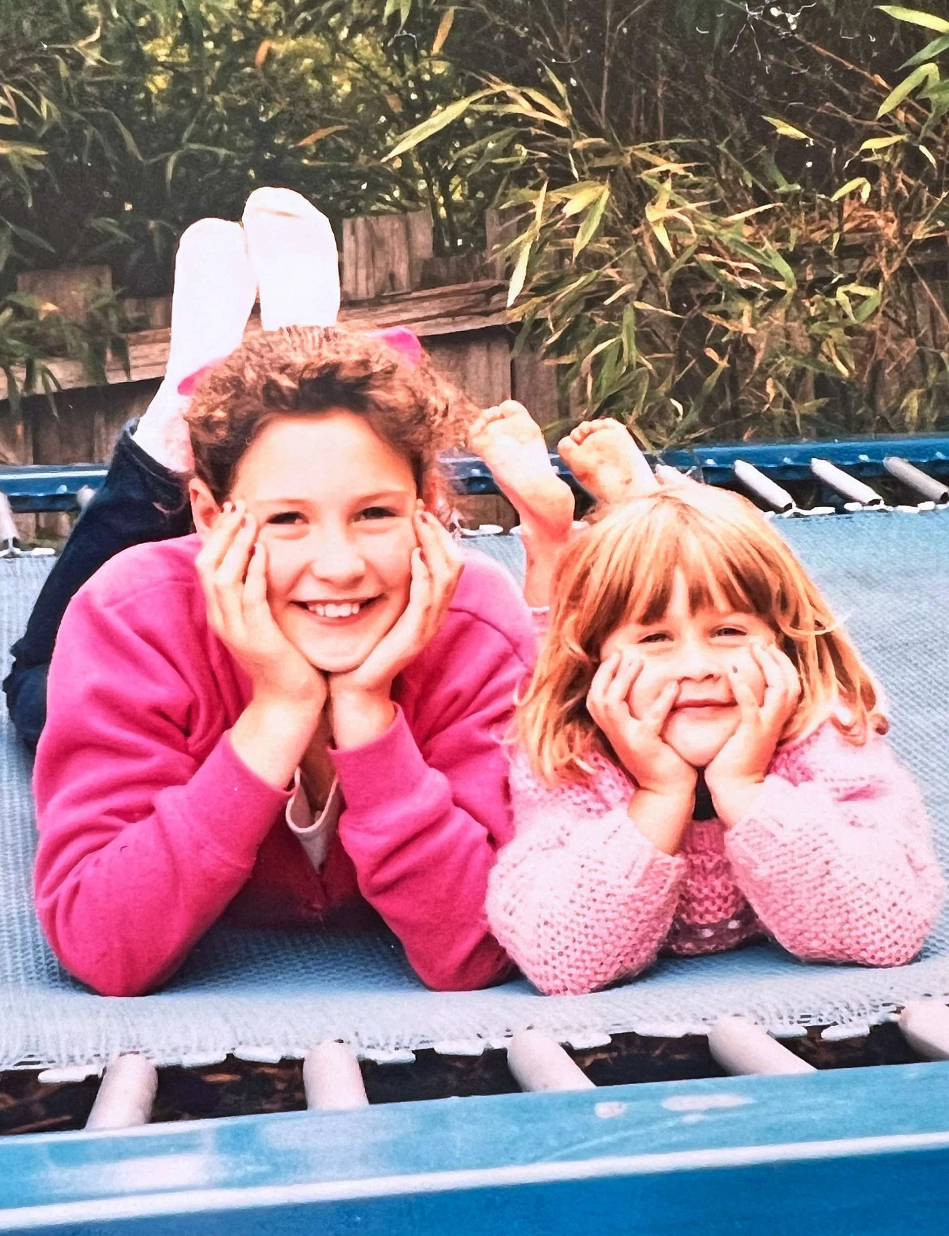 Fiona and Penny laying on a trampoline together when they were young