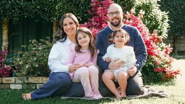 Laura Tupou sitting on the lawn with her family
