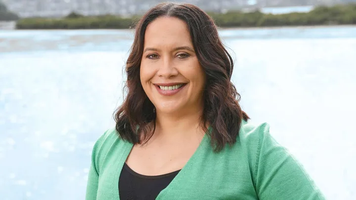 Kura Forrester smiling in a green cardigan