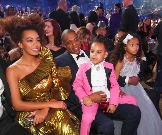 Four people in formal attire seated in an audience at a gala event.