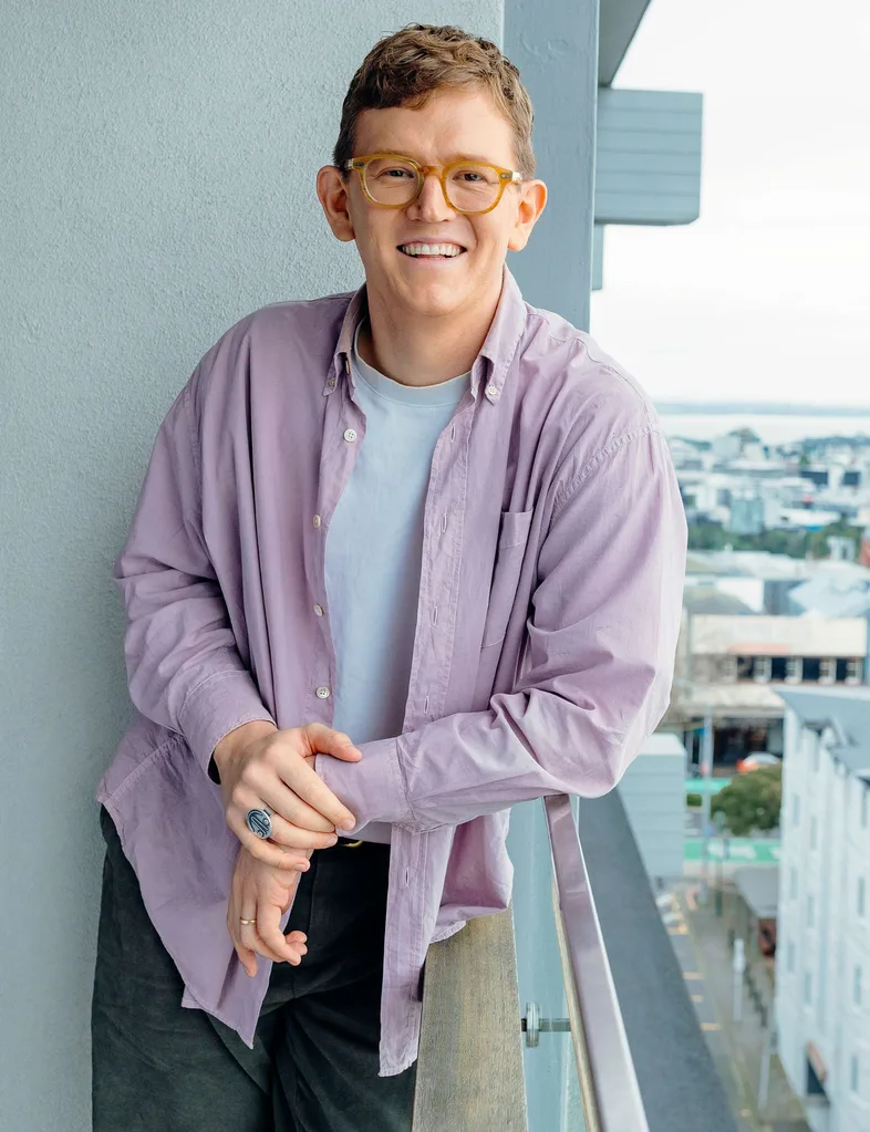 Chris leaning on the banister of his balcony