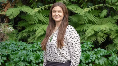 Siobhan smiling in front of bushes
