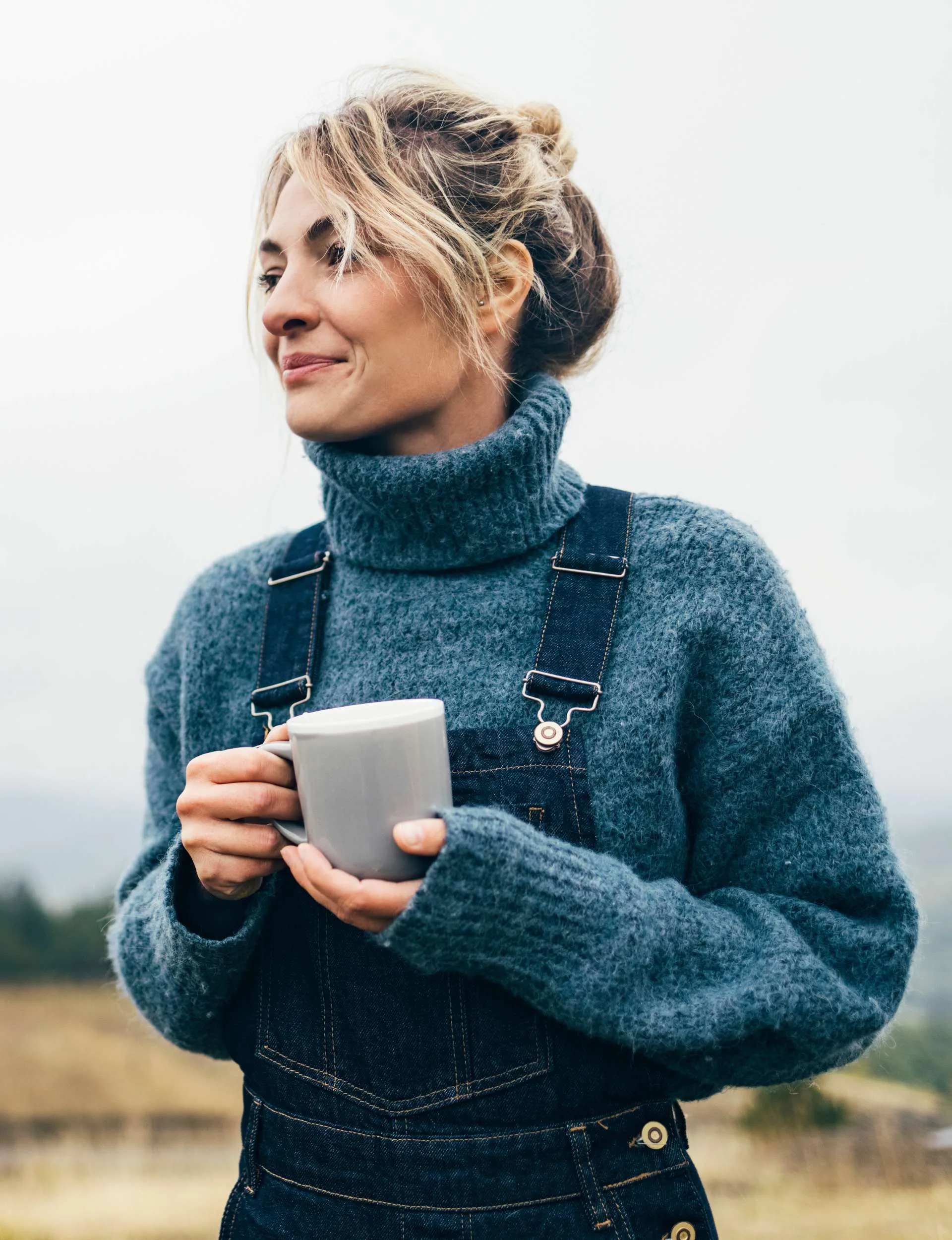 A woman smiling with a mug because she is her own bestie