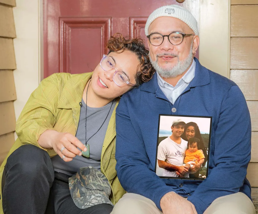 Ngā Rorirori creators Hone and Maarire sitting on their doorstep with a photo of Nancy