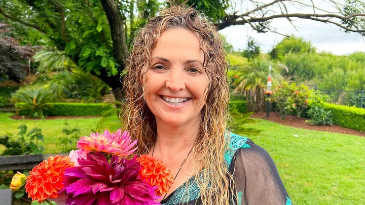 Rachel Weston holding big red and pink flowers