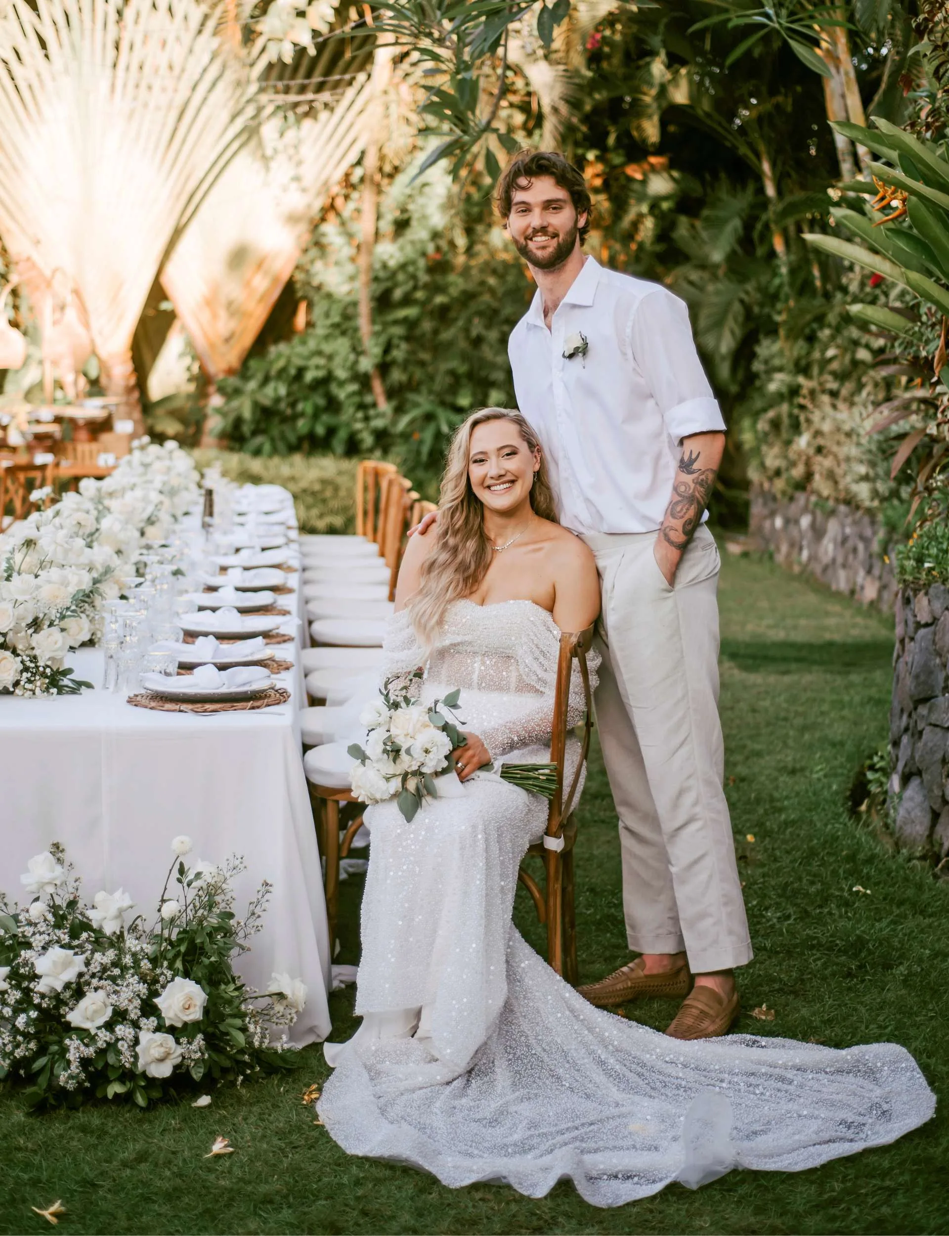 Brayden Inger standing behind his bride, Georgina Fisher at their wedding table