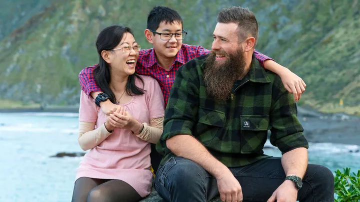 Alice Cai and her son with his big buddy, all sitting on a boulder together