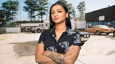 Shoshana Sachi standing with her arms crossed in a car yard