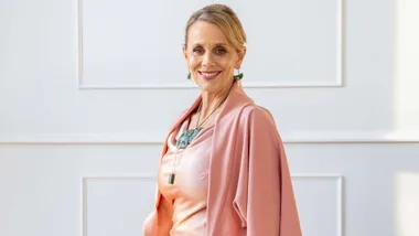 Dame Hinewehi Mohi smiling in a silk pink dress