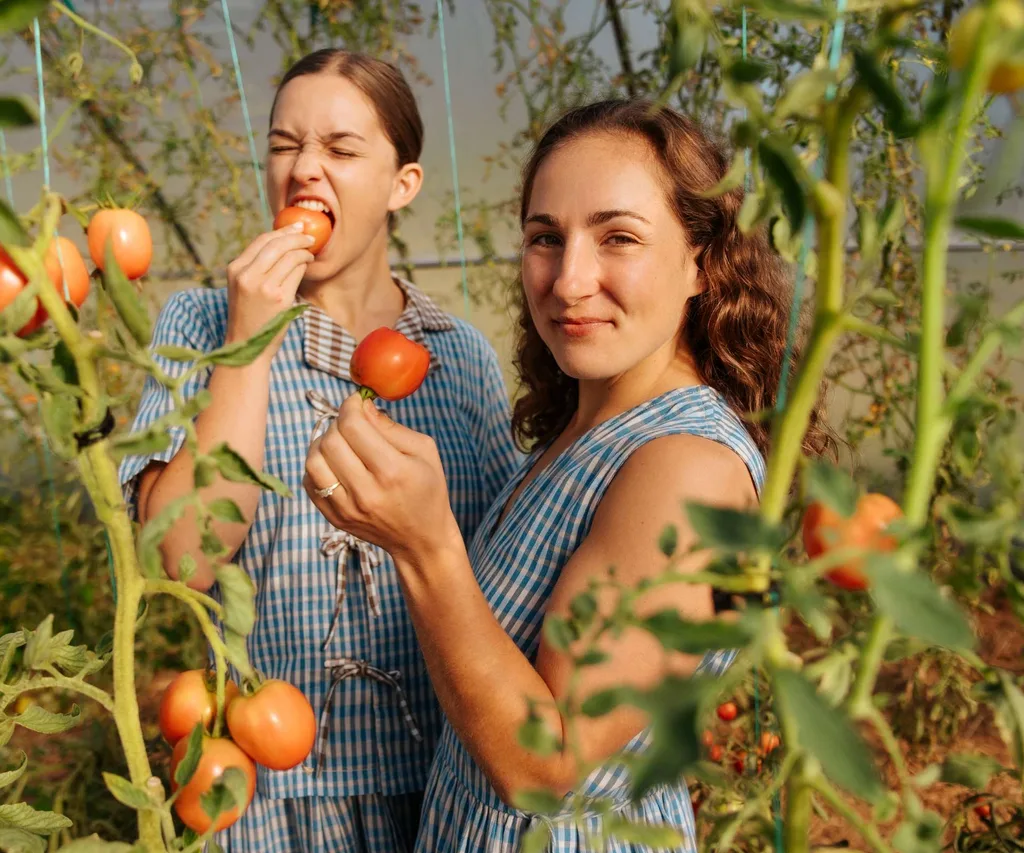 Two Raw Sisters Rosa and Margo in a glasshouse with tomato plants